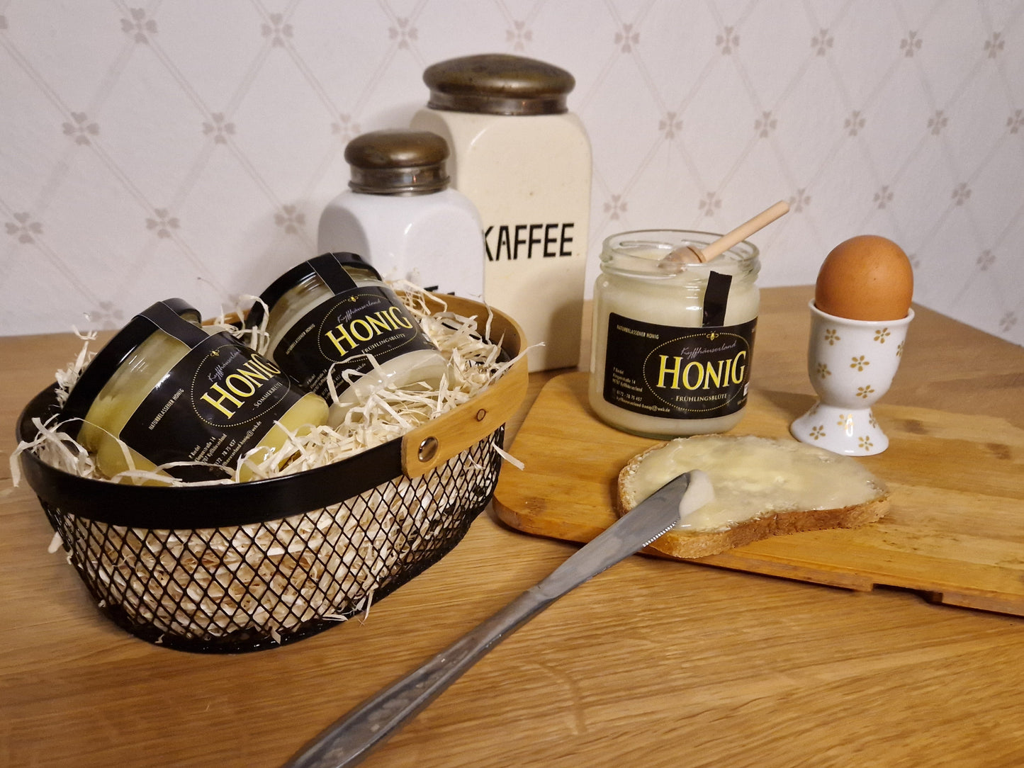 ein geöffnetes Glas Feincremiger Sommerblütenhonig der auf ein Brot gestrichen ist.